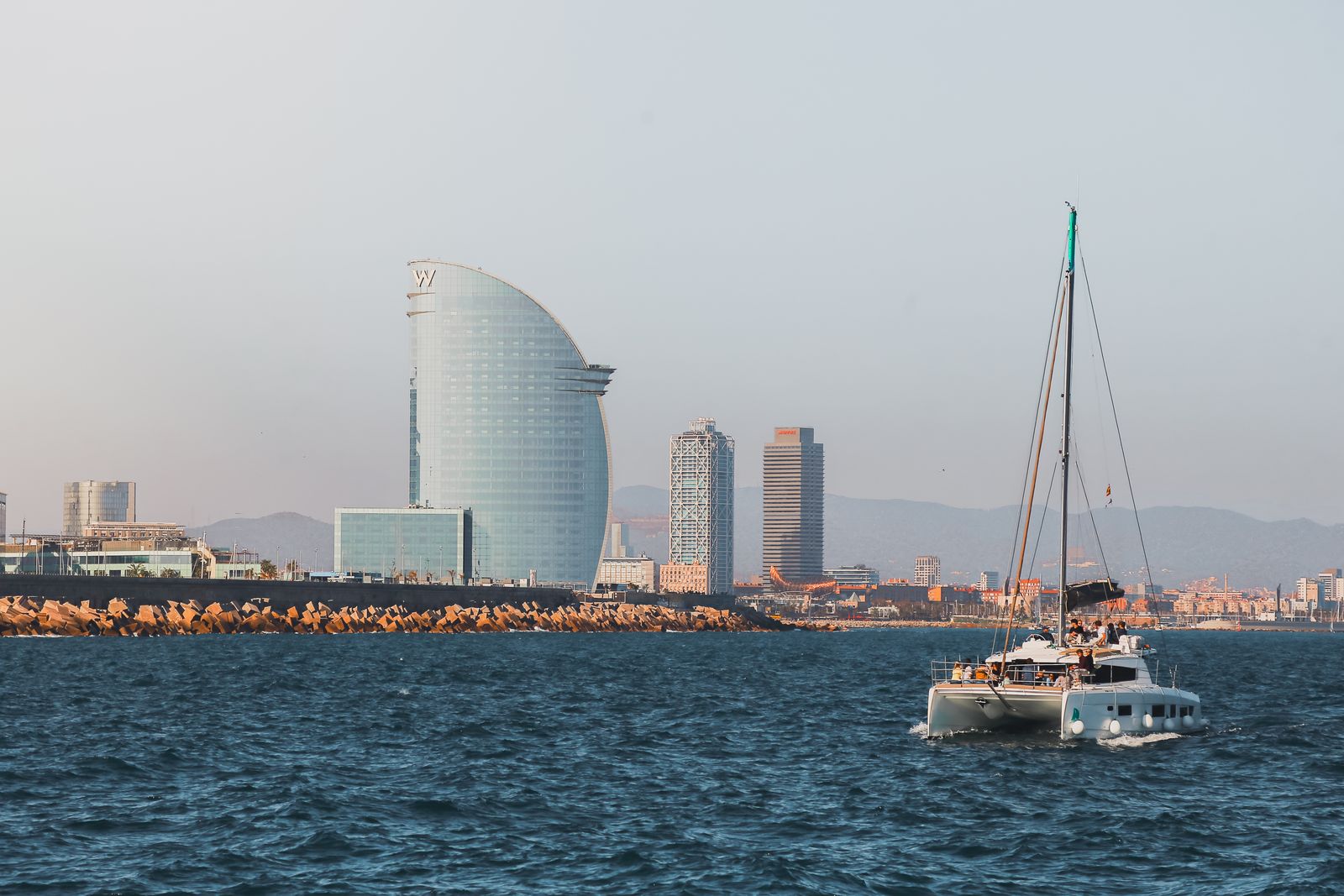 Catamaran off Barcelona with the W Hotel and waterfront skyline behind it
